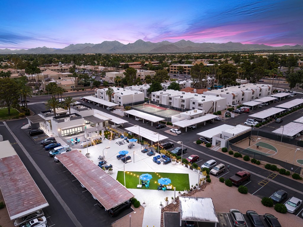an aerial view of the community at sunset with mountains in the background