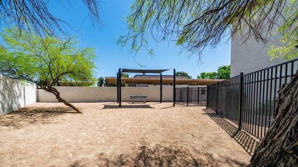 a courtyard with a fence and a bench in front of a building