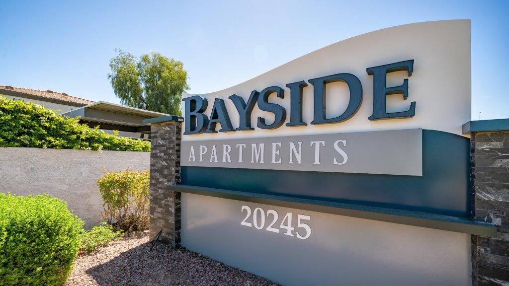 a sign for bayside apartments in front of a building