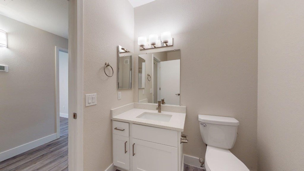 a white bathroom with a toilet and a sink