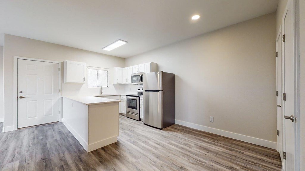 an empty kitchen with a refrigerator and a sink