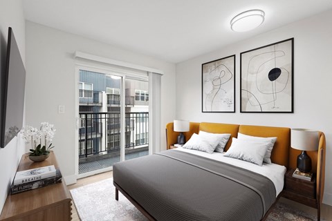 a bedroom with a large window and a bed with a yellow headboard