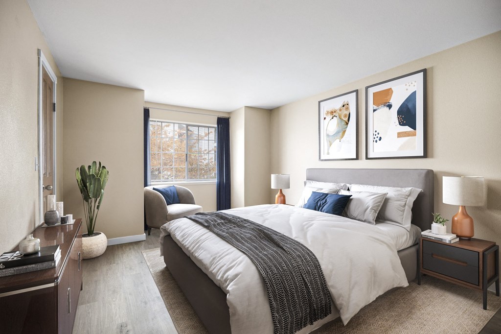 a bedroom with a large bed and a chair in front of a window