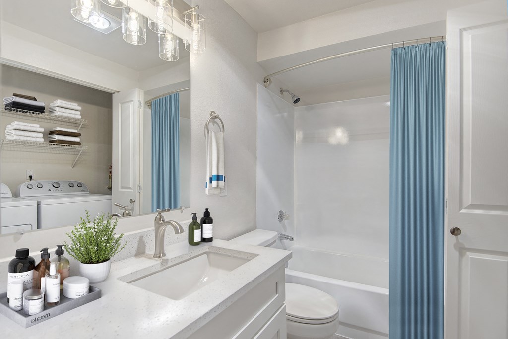 a bathroom with white walls and a blue shower curtain