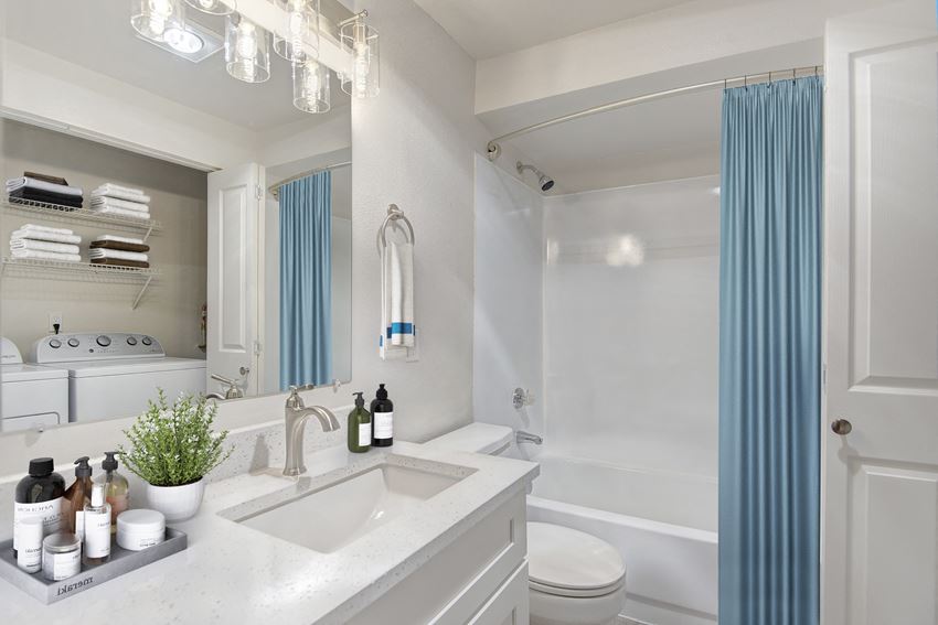 a bathroom with white walls and a blue shower curtain - Photo Gallery