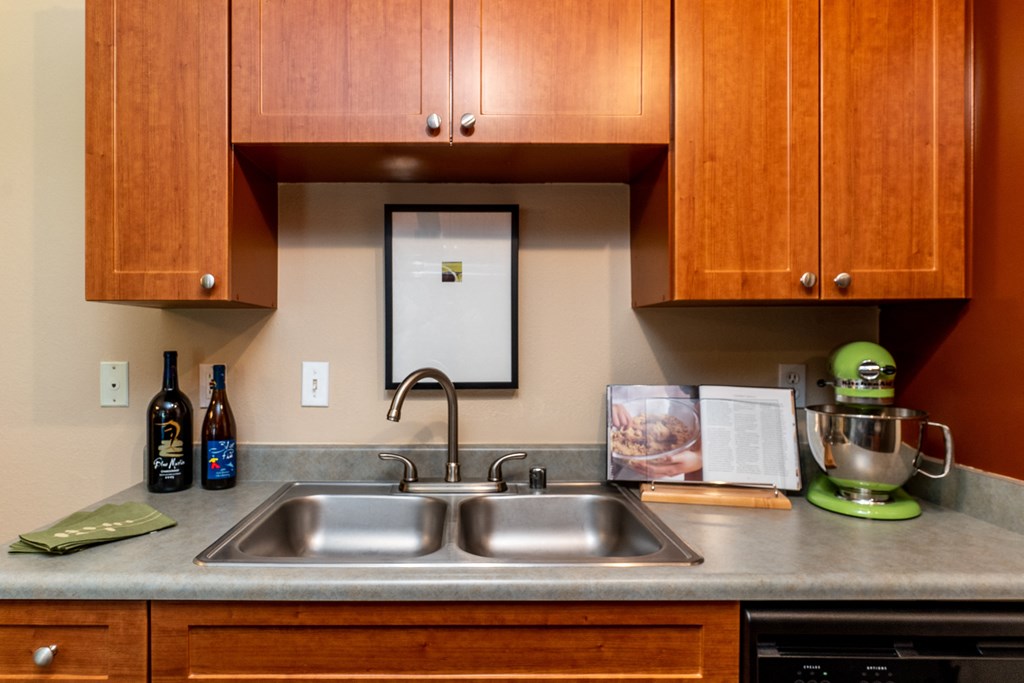 a kitchen with wood cabinets and a stainless steel sink