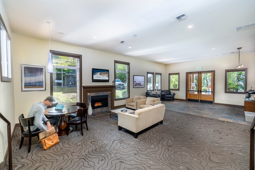 a man sitting at a table in a room with a fireplace