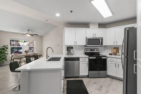 A modern kitchen with white cabinets and stainless steel appliances.