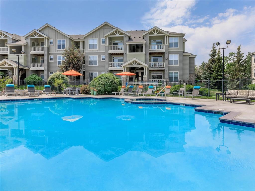 a large pool with an apartment building in the background