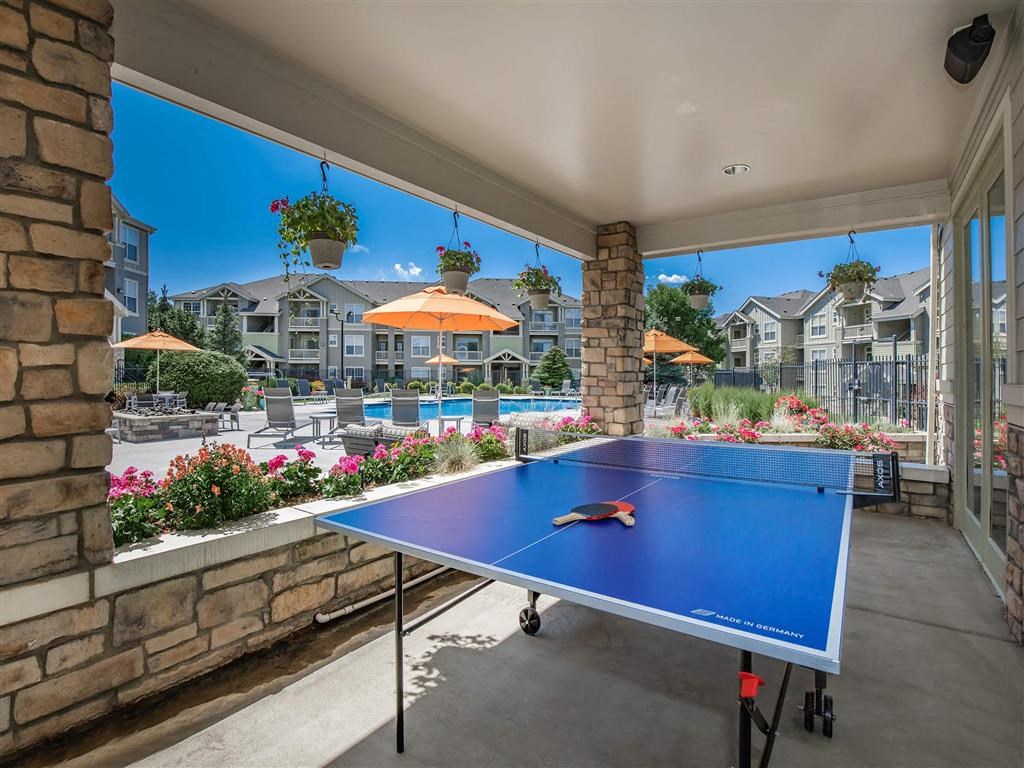 the pool area has a ping pong table and views of the pool and resort
