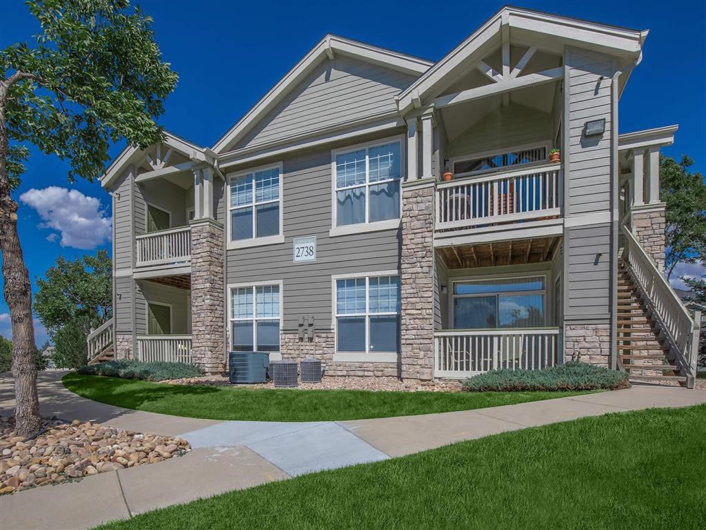 an apartment building with a sidewalk in front of it