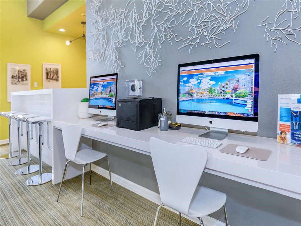 a computer desk with two monitors and two chairs