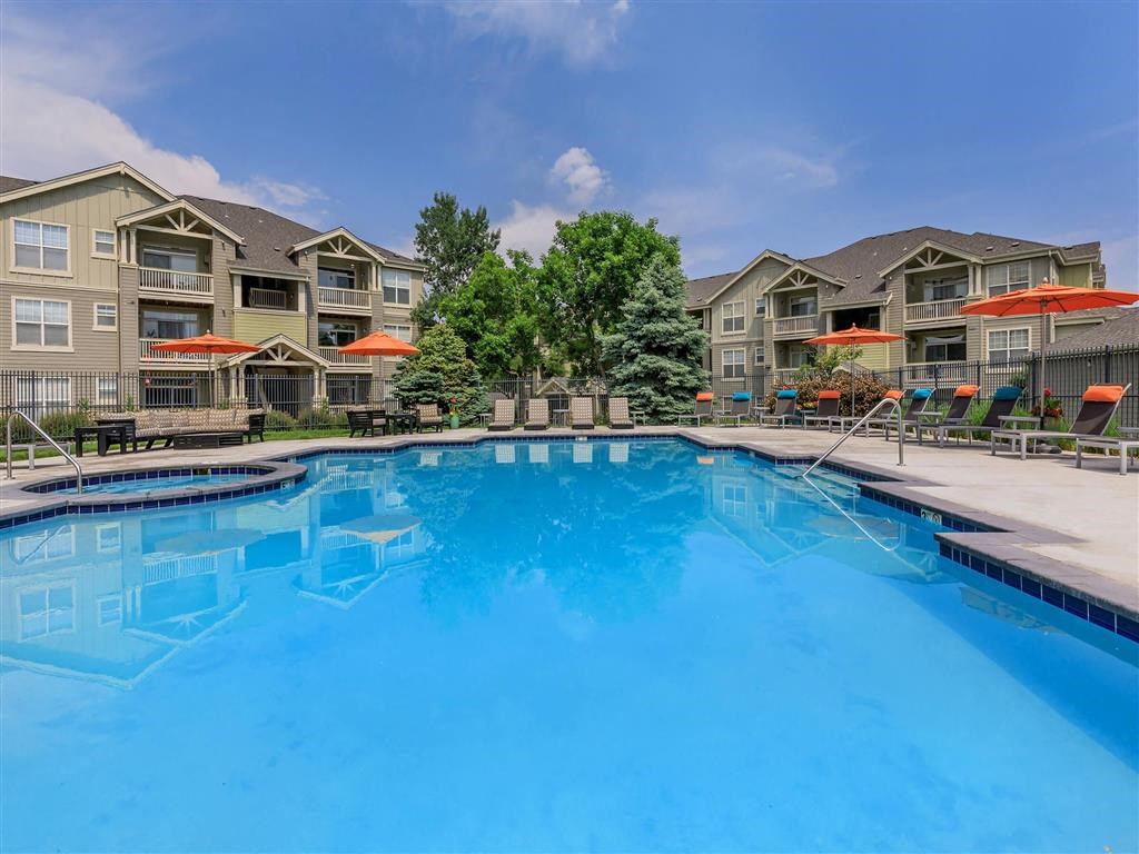 a swimming pool with apartment buildings in the background
