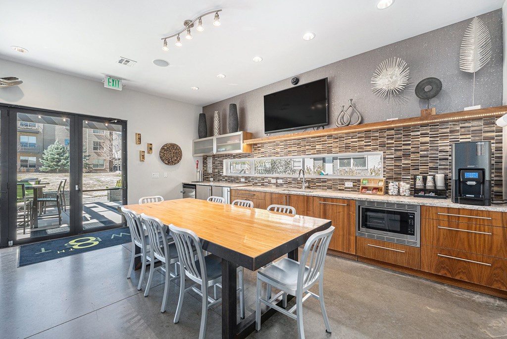 A modern kitchen with a wooden table and chairs.