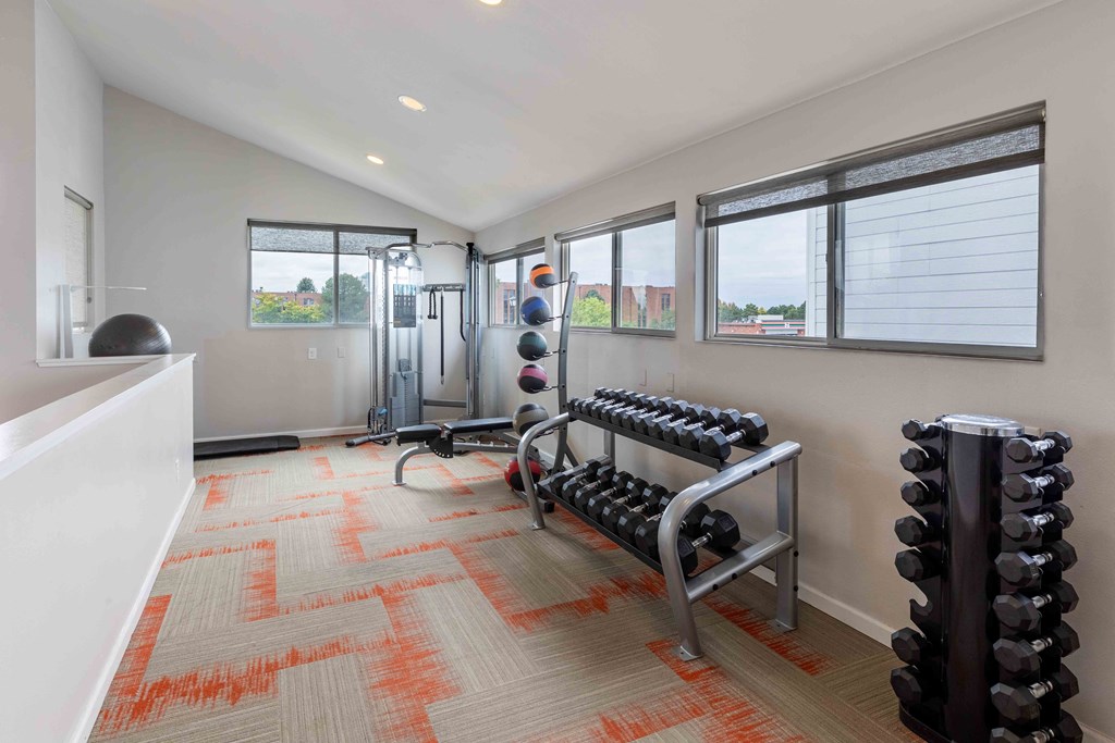 a workout room with weights and a large window