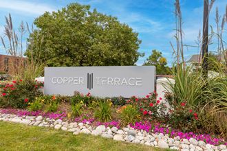 a sign for cooper terrace in front of flowers and trees
