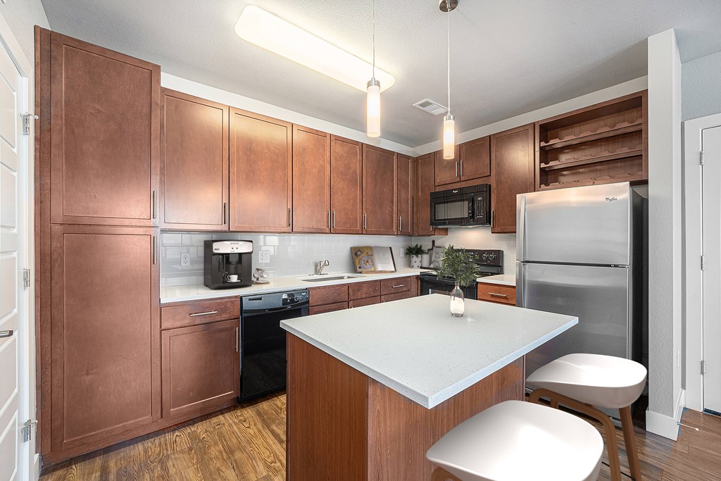 A kitchen with brown cabinets and a white island.