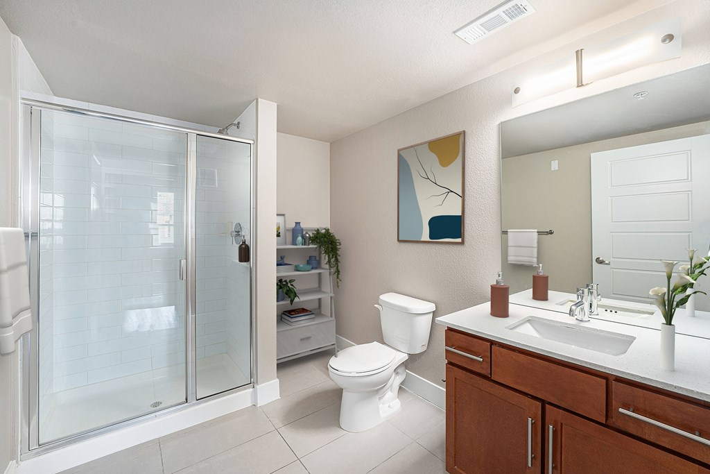 A bathroom with a toilet, sink, and shower.