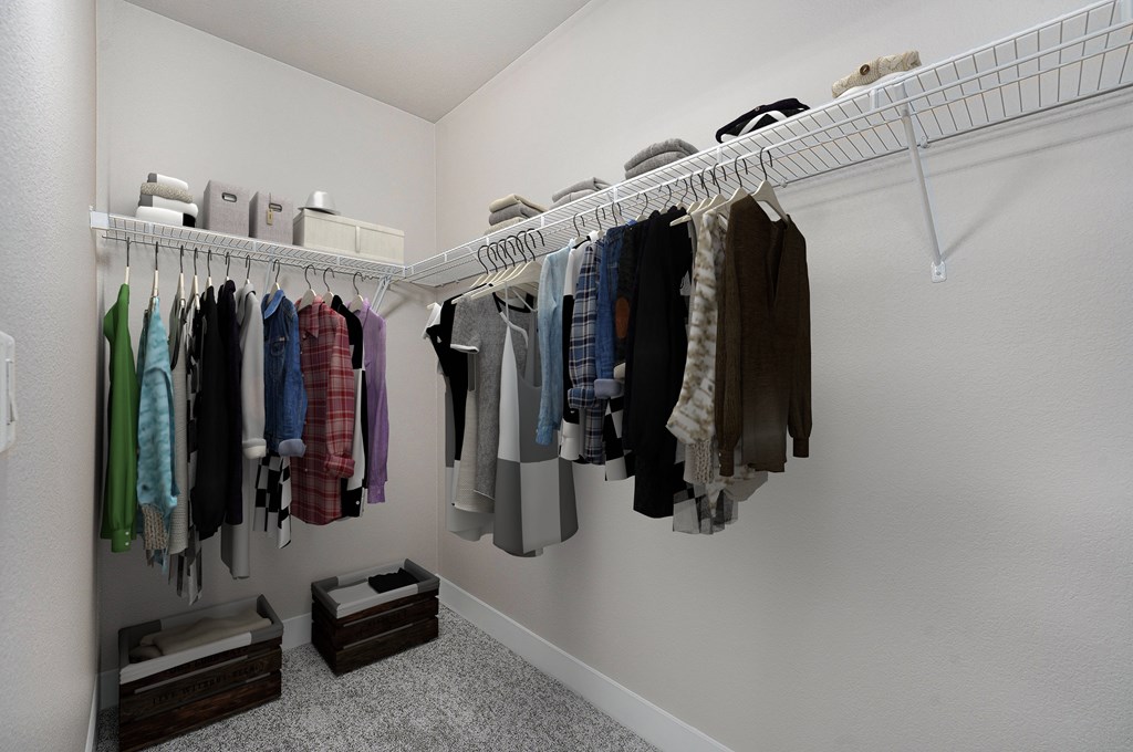 A white closet with clothes hanging on a rail.
