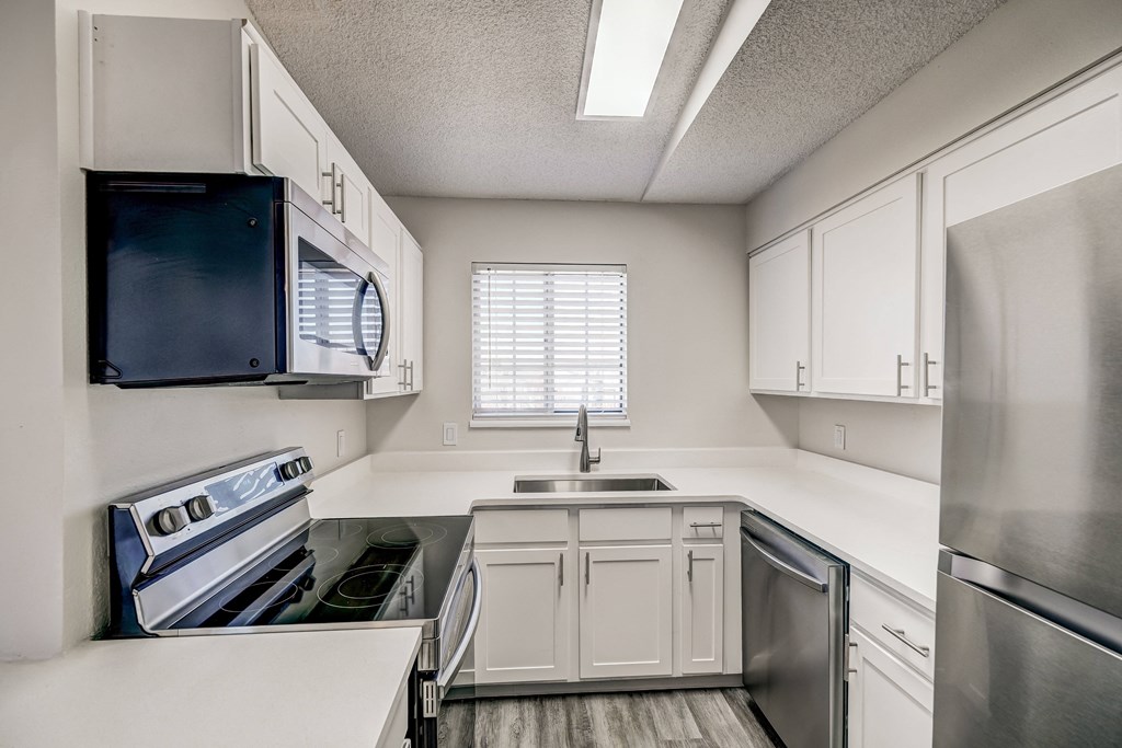 a kitchen with white cabinets and stainless steel appliances