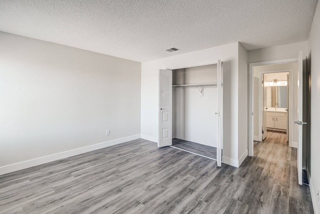 a bedroom with hardwood flooring and white walls