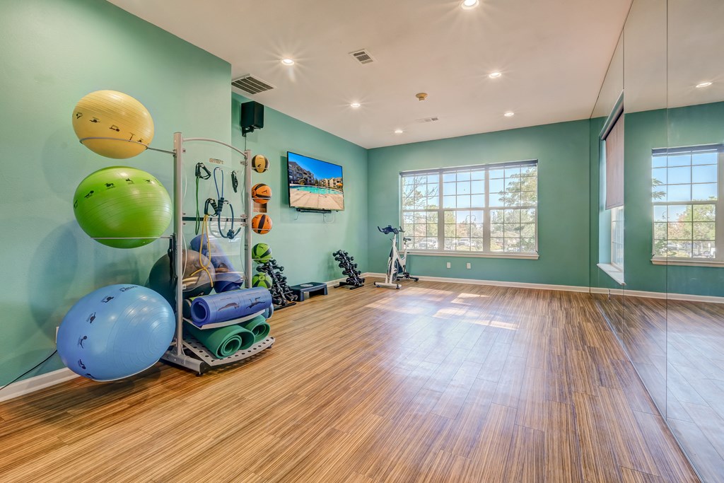 the exercise room is equipped with a large window and green walls