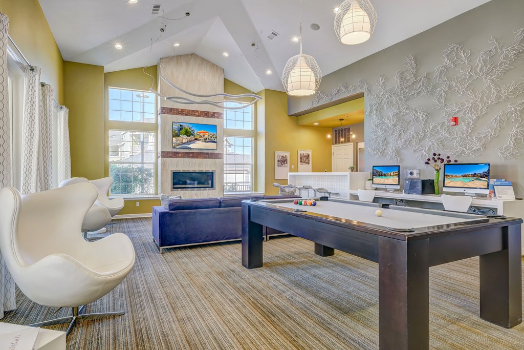 a game room with a pool table and couches