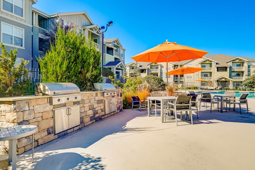 our patio with tables and chairs and umbrellas at our apartments at the park
