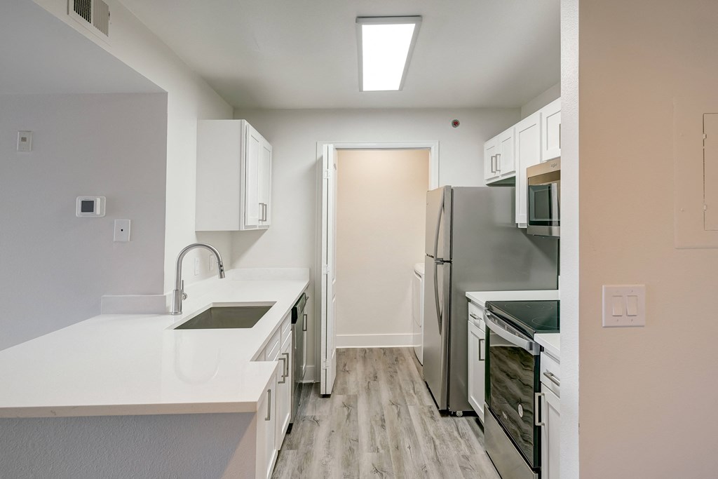 a kitchen with white cabinets and stainless steel appliances