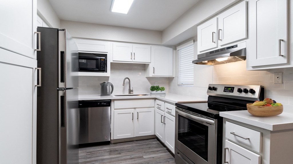 a kitchen with white cabinets and stainless steel appliances