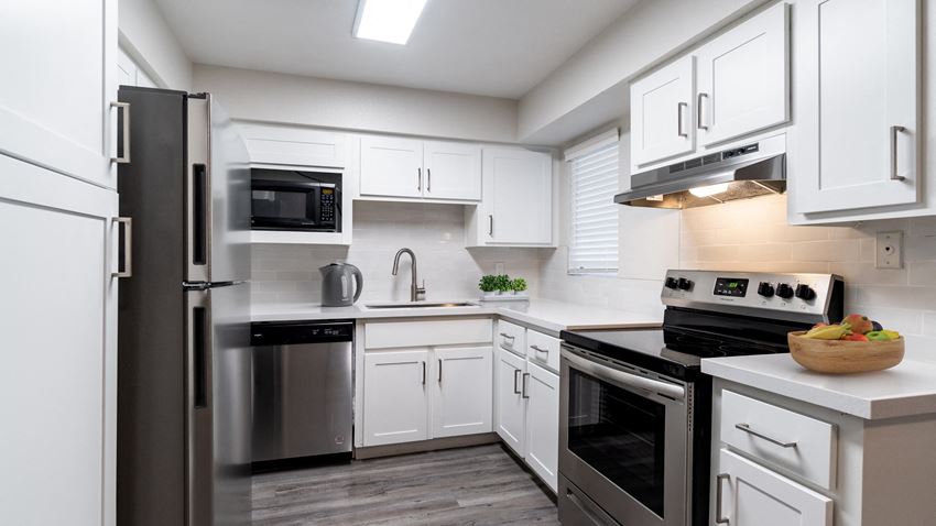 a kitchen with white cabinets and stainless steel appliances - Photo Gallery