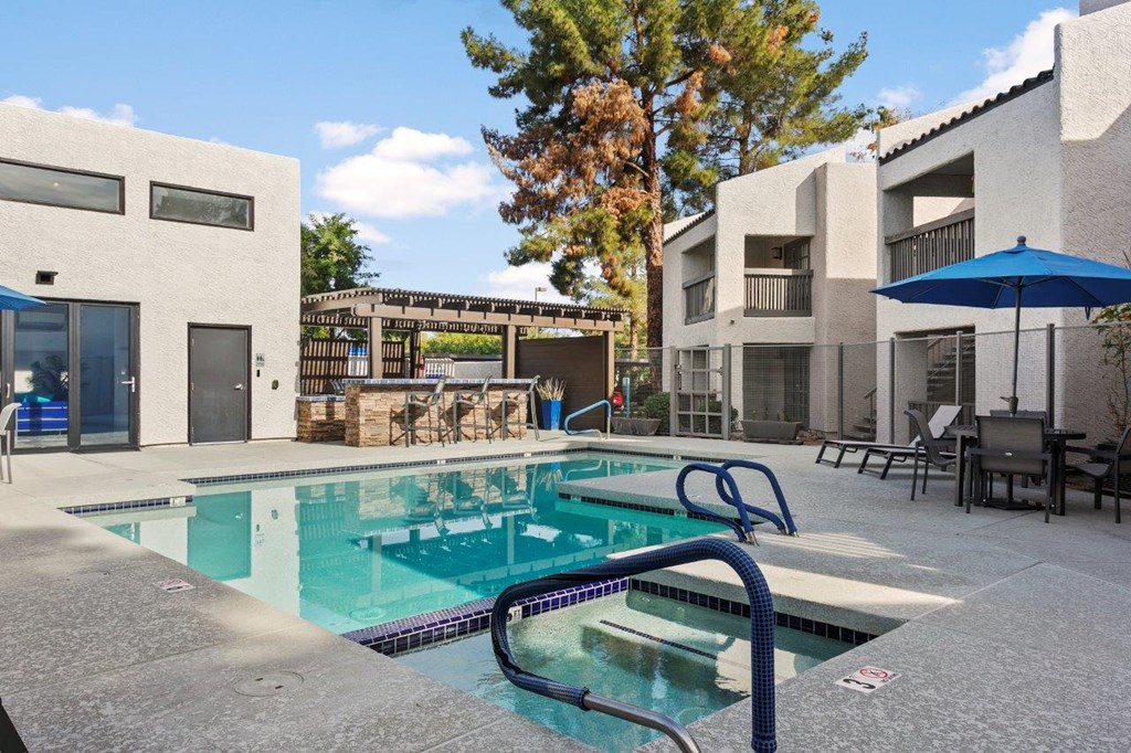 Del Sol Apartments Pool with Lounge Chairs and BBQ Area