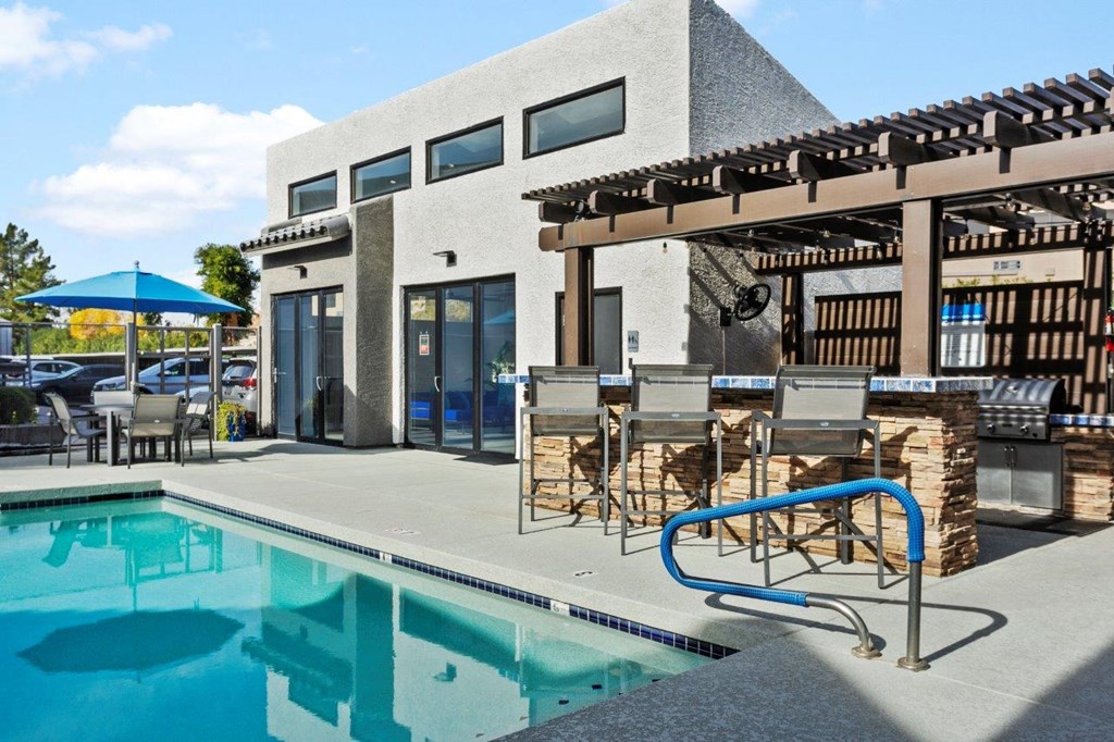 Del Sol Apartments Pool with Lounge Chairs and BBQ Area