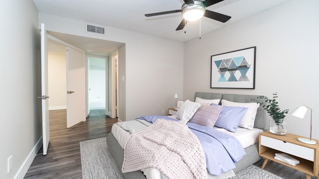 a bedroom with a ceiling fan and hardwood flooring