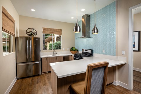 a kitchen with a large island and a stainless steel refrigerator