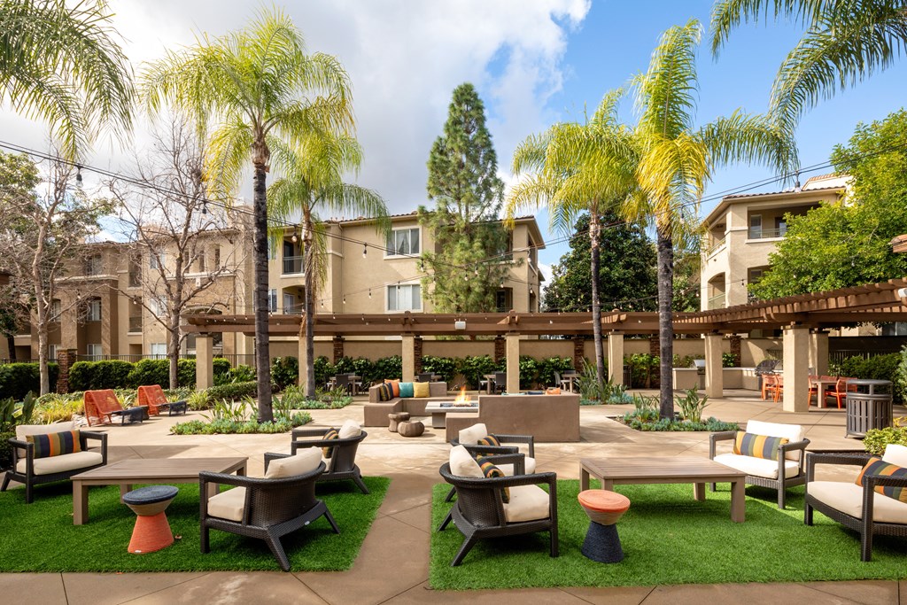 a courtyard with tables and chairs and palm trees