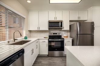 Apartments for Rent Oceanside CA - Stone Arbor - White Kitchen with Wood-Style Flooring and Stainless Steel Appliances