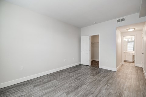 a bedroom with hardwood floors and grey walls