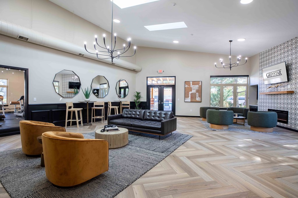 a lobby with couches and chairs and a bar with mirrors
