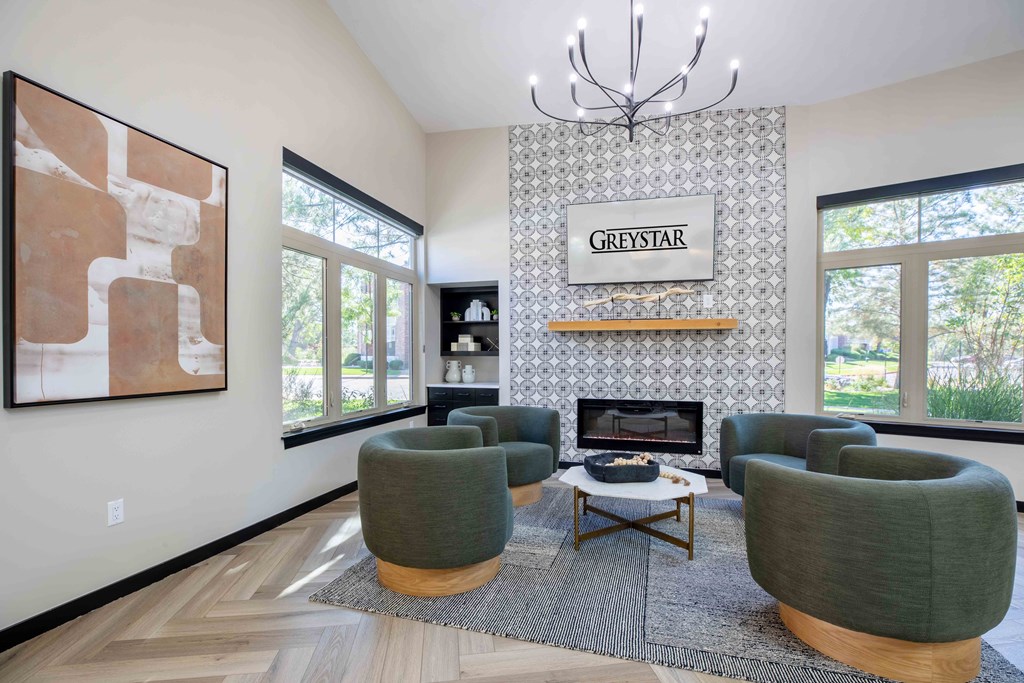a living room with green chairs and a fireplace