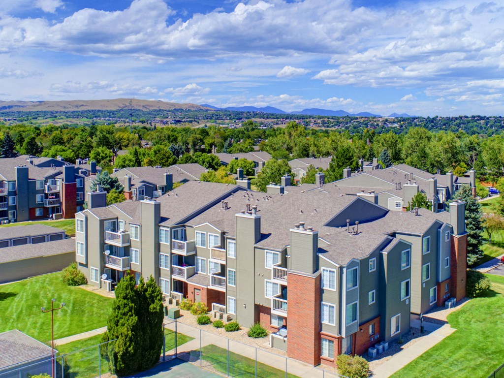 an aerial view of an apartment complex with green grass and trees