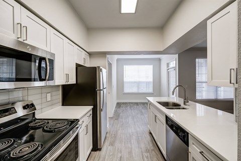 a kitchen with white cabinets and stainless steel appliances