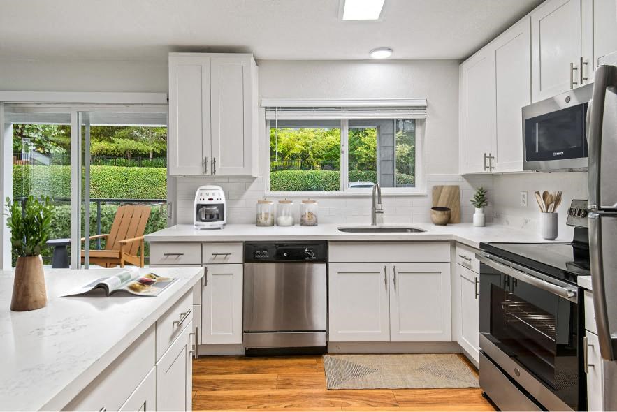 a kitchen with white cabinets and a stainless steel refrigerator