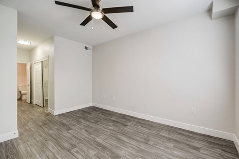 a bedroom with hardwood floors and a ceiling fan
