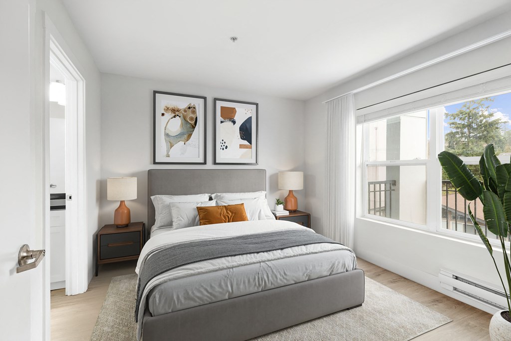 a bedroom with a large window and a large bed