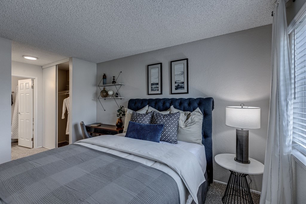 a bedroom with a bed and a nightstand with a lamp