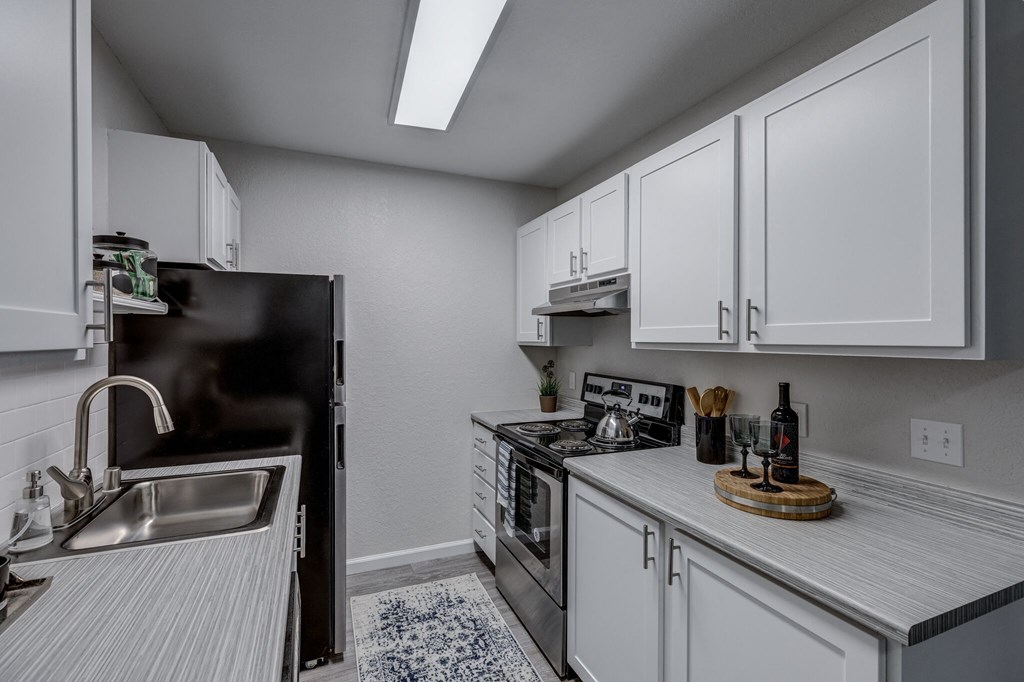 a kitchen with white cabinets and stainless steel appliances