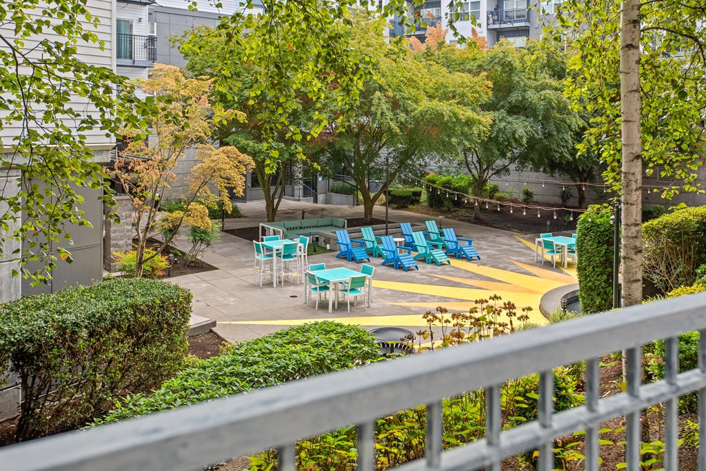 a patio with blue chairs and a fountain in front of a building