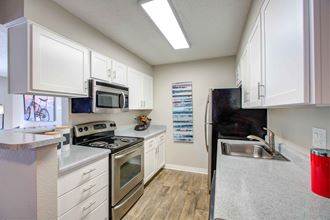 a kitchen with white cabinets and stainless steel appliances - Photo Gallery