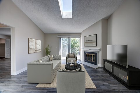 A modern living room with a grey sofa and a fireplace.